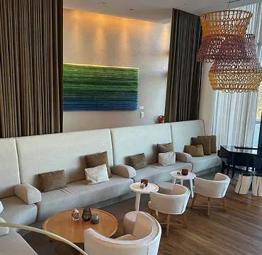 Lobby der Seezeitlodge mit Polsterbank, Sesseln und Vorhängen