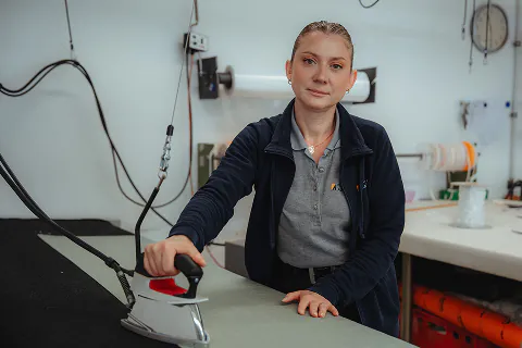 Olga Fegler bei der Arbeit mit dem Dampfbügeleisen in der Werkstatt