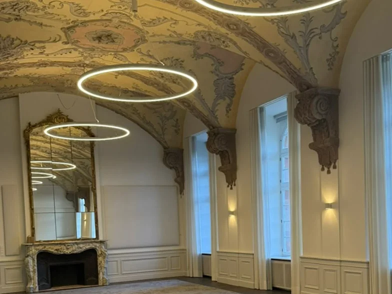 Refektorium von Villeroy & Boch mit Stuckdecke, Ringleuchten und Vorhängen