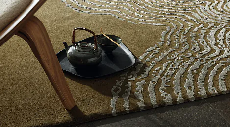 Designteppich mit Wellenmuster, darauf ein Tablett mit Teekanne