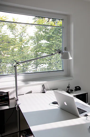 Jalousie am Fenster über einem Schreibtisch