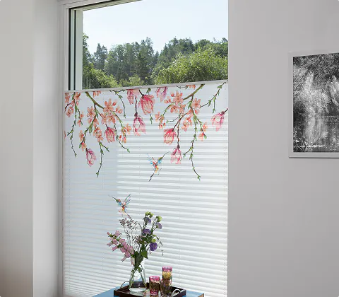 Plissee mit Blütenmotiv am Fenster eines hellen Raums