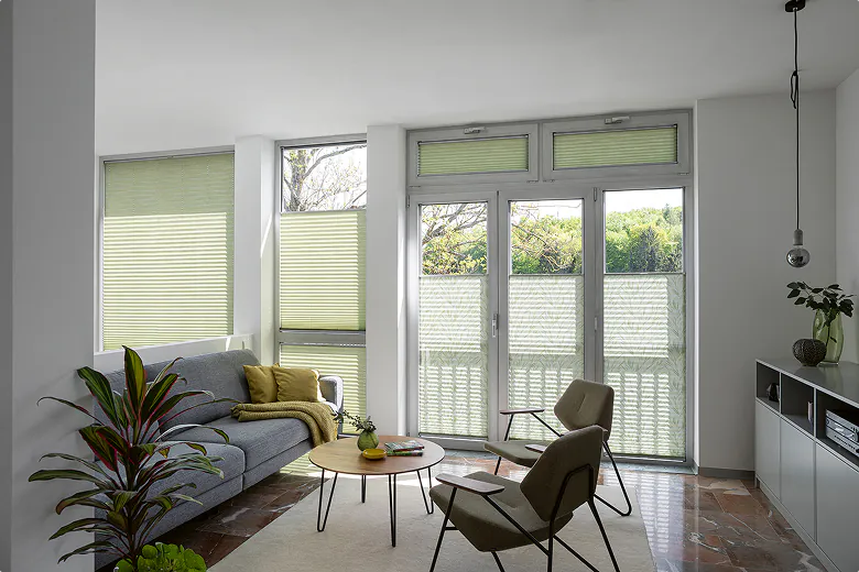 Wohnzimmer mit Plissees an den Fenstertüren