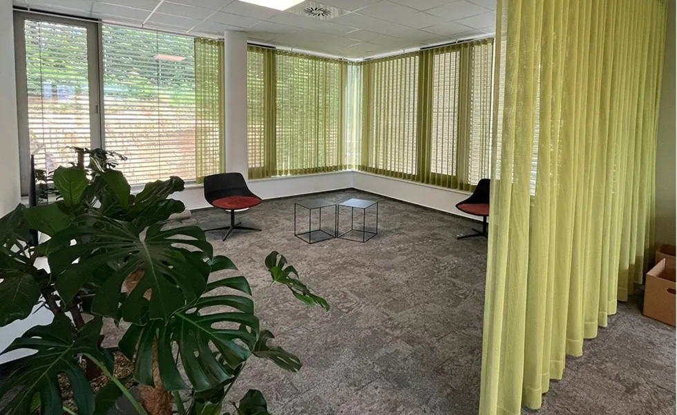 Bürogebäude in St. Ingbert: Sitzbereich mit grünen Vorhängen und Teppichboden