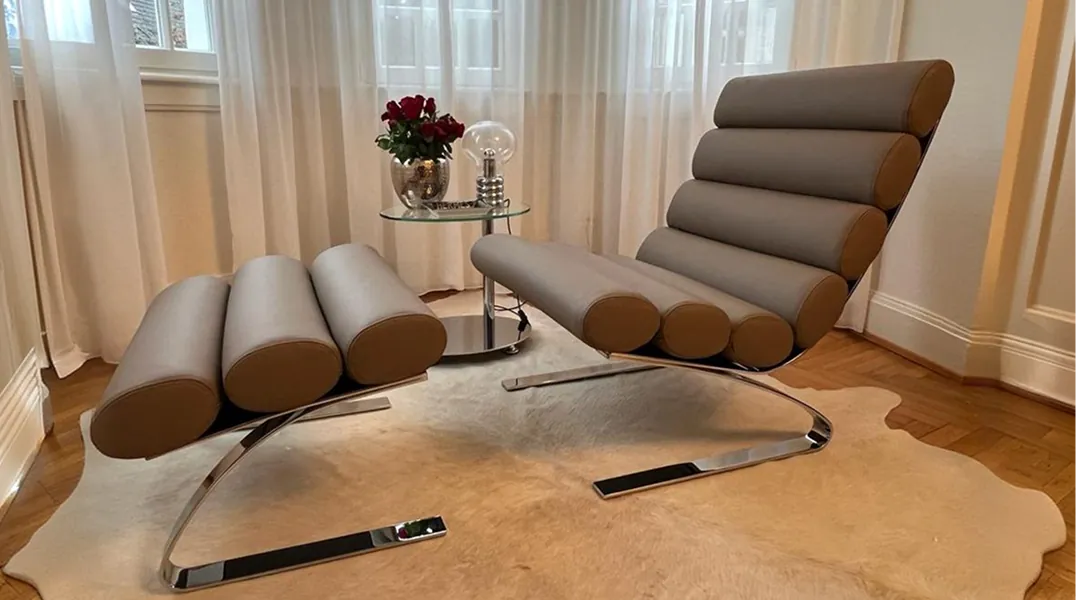Designsessel mit Hocker in Saarbrücken, neu bezogen in grauem Leder