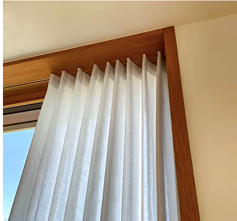 Weißer Wellenvorhang an einem Fenster mit Holzrahmen in Homburg