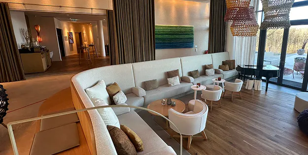 Lobby der Hotel Seezeitlodge in Gonnesweiler mit langer Polsterbank und Parkettboden
