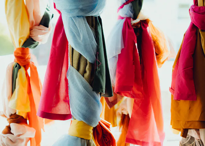 Bunte Vorhangstoffe in Rot, Orange und Blau, zu Knoten gebunden